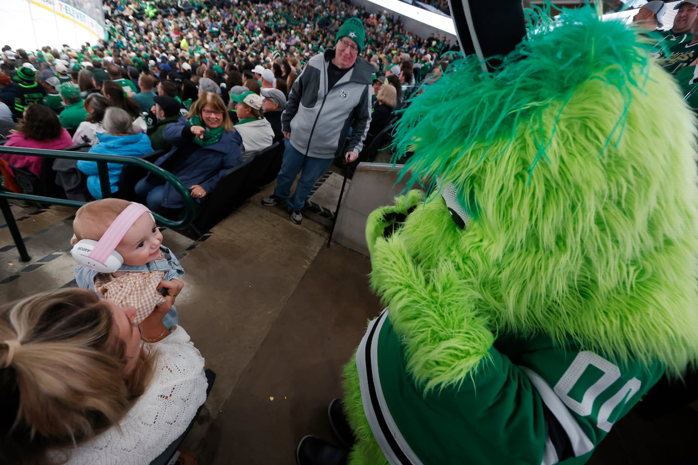 Dallas Stars mascot Victor E. Green plays hide and go seek with 7-month old Pippa McRedmond...