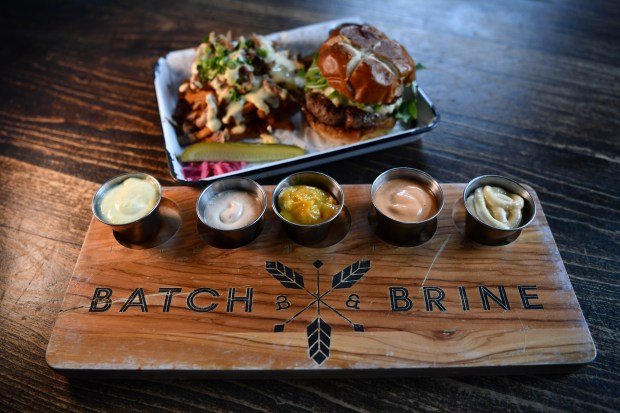 A variety of sauces are served with a Blue Burger with duck confit and cheese hand cut french fries served at the Batch & Brine restaurant in Lafayette, Calif., on Friday, March 22, 2024. (Jose Carlos Fajardo/Bay Area News Group)