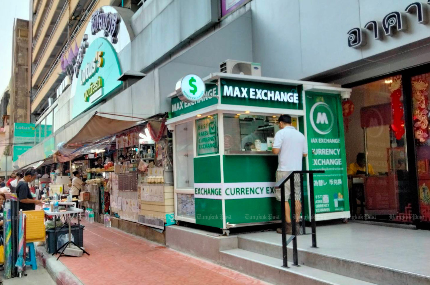 A tourist prepares to change money at a currency exchange booth in Bangkok's Chinatown, Yaowarat, on March 18, 2024. (Photo: Nittaya Nattayai)
