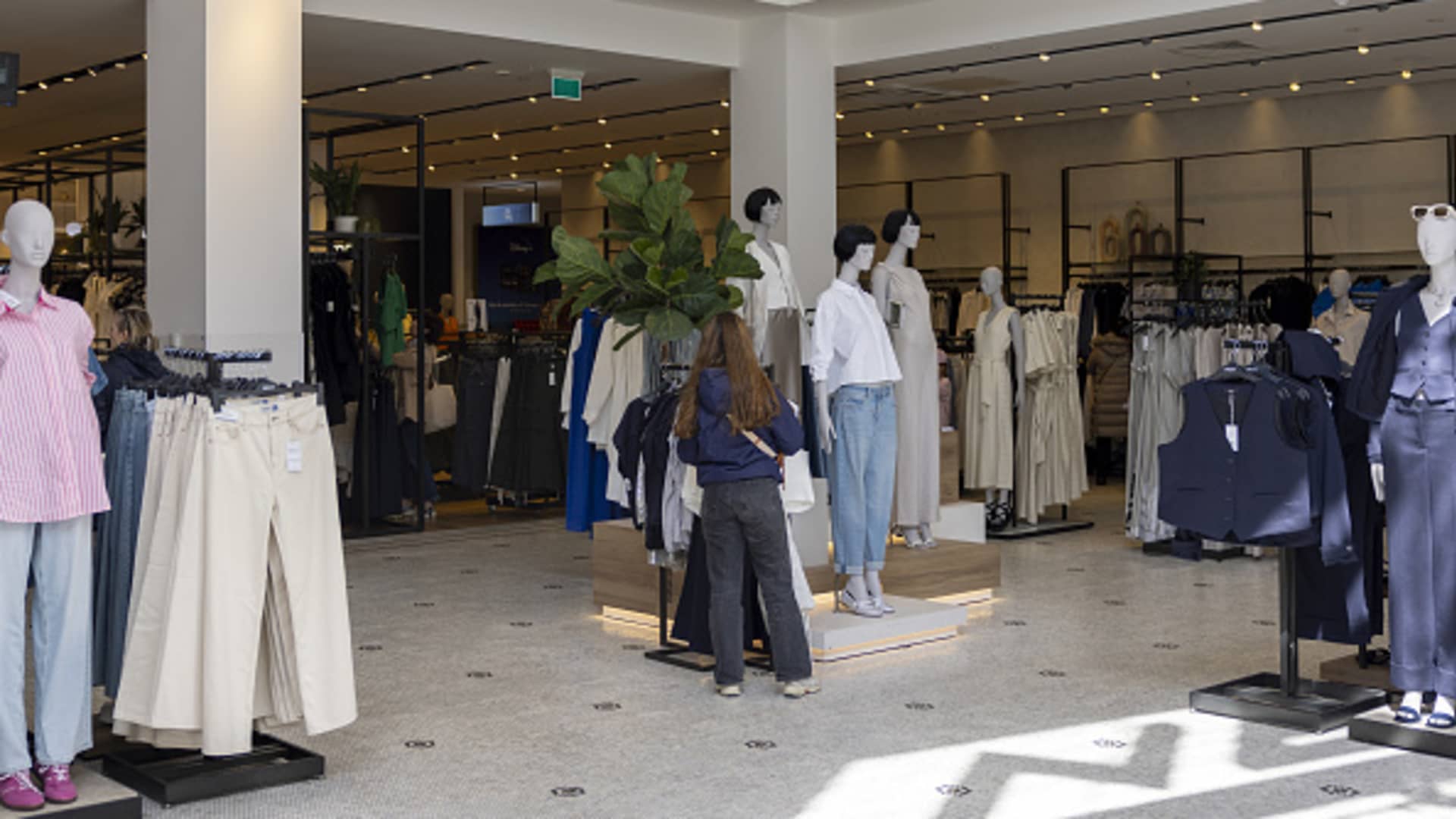A shopper browses clothes on display at a Next Plc store in London, UK, on Monday, April 29, 2024.