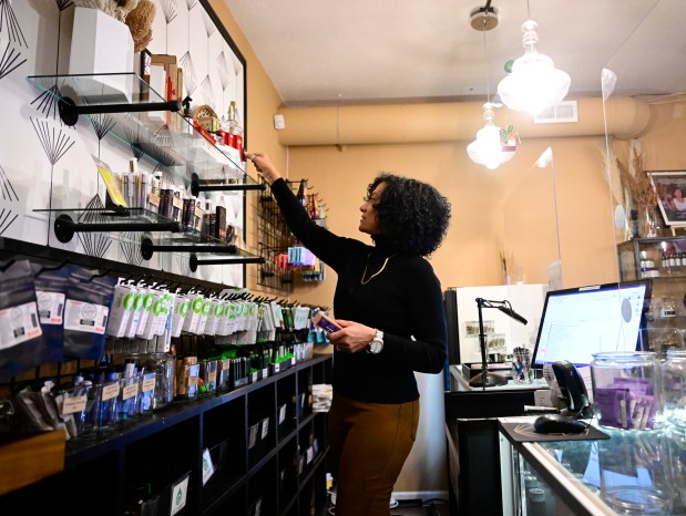 Simply Pure dispensary owner Wanda James goes through some of the products behind the counter at her shop in Denver on Thursday, Dec. 28, 2023. (Photo by Andy Cross/The Denver Post)