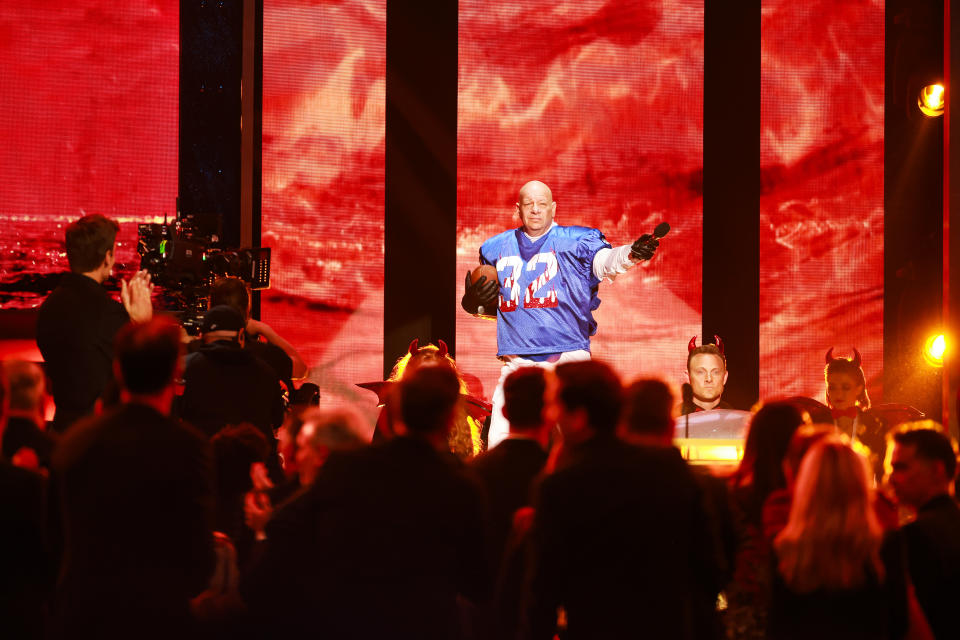 Jeff Ross wears a football jersey onstage.